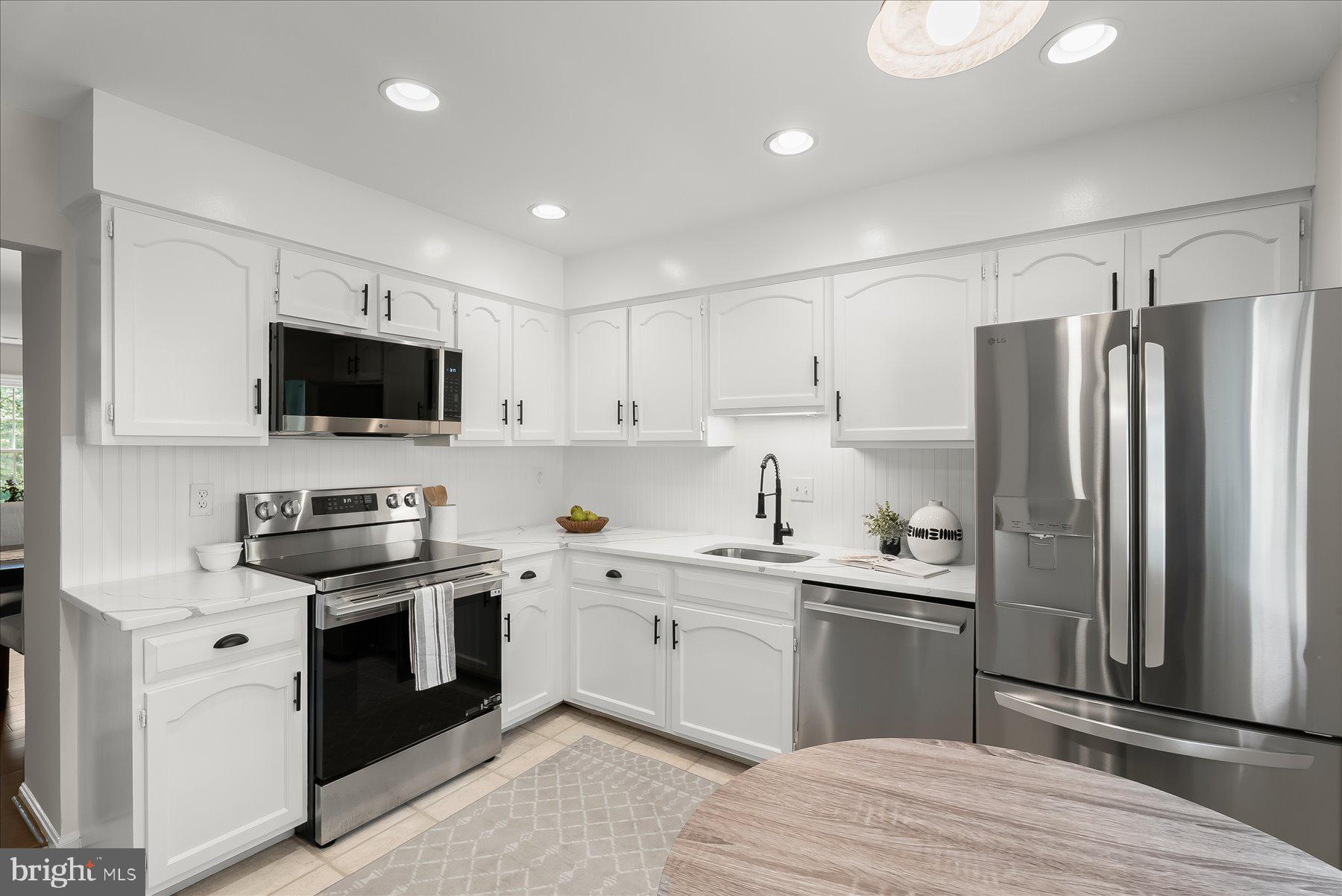 1530 Tanyard Hill Road Gaithersburg, MD 20879 - Photo 7 of 40 a kitchen with granite countertop a sink stainless steel appliances and white cabinets