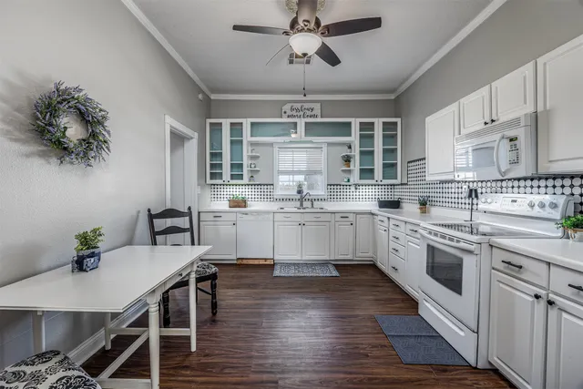 a kitchen with cabinets wooden floor and stainless steel appliances