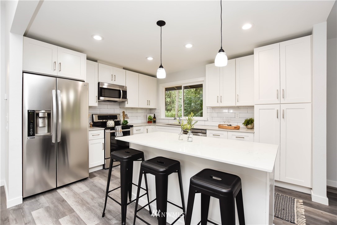 322 170th Place Southwest Bothell, WA 98012 - Photo 13 of 37 a kitchen with kitchen island white cabinets and stainless steel appliances