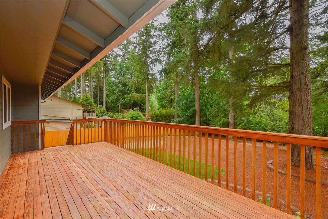 322 170th Place Southwest Bothell, WA 98012 - Photo 34 of 37 a balcony with wooden floor and trees in the back