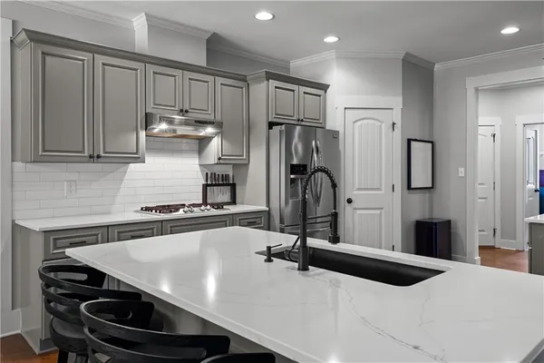 a kitchen with stainless steel appliances kitchen island granite countertop a refrigerator and a stove top oven