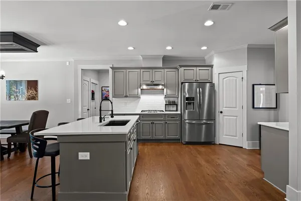 a kitchen with kitchen island a sink table and chairs