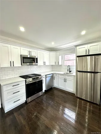 a kitchen with granite countertop white cabinets and stainless steel appliances