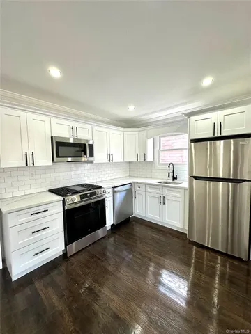 a kitchen with granite countertop white cabinets and stainless steel appliances
