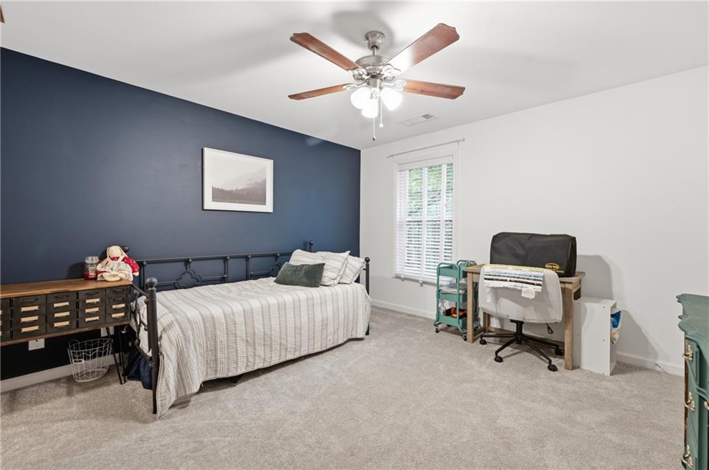 1007 Olde Mill Lane Norcross, GA 30093 - Photo 23 of 32 a bedroom with a bed and a chandelier