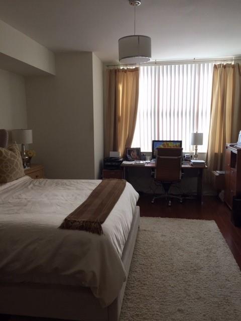 3340 Northeast 190th Street, Unit 1105 Miami, FL 33180 - Photo 16 of 17 a bedroom with a bed and a chandelier