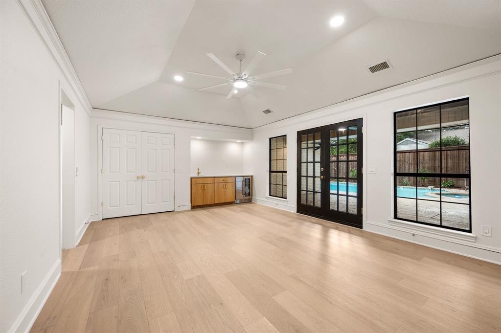 6403 Genstar Lane Dallas, TX 75252 - Photo 12 of 34 Family room with light wood flooring, wet bar and beverage fridge.