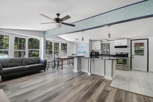 a living room with stainless steel appliances kitchen island granite countertop furniture and a kitchen view