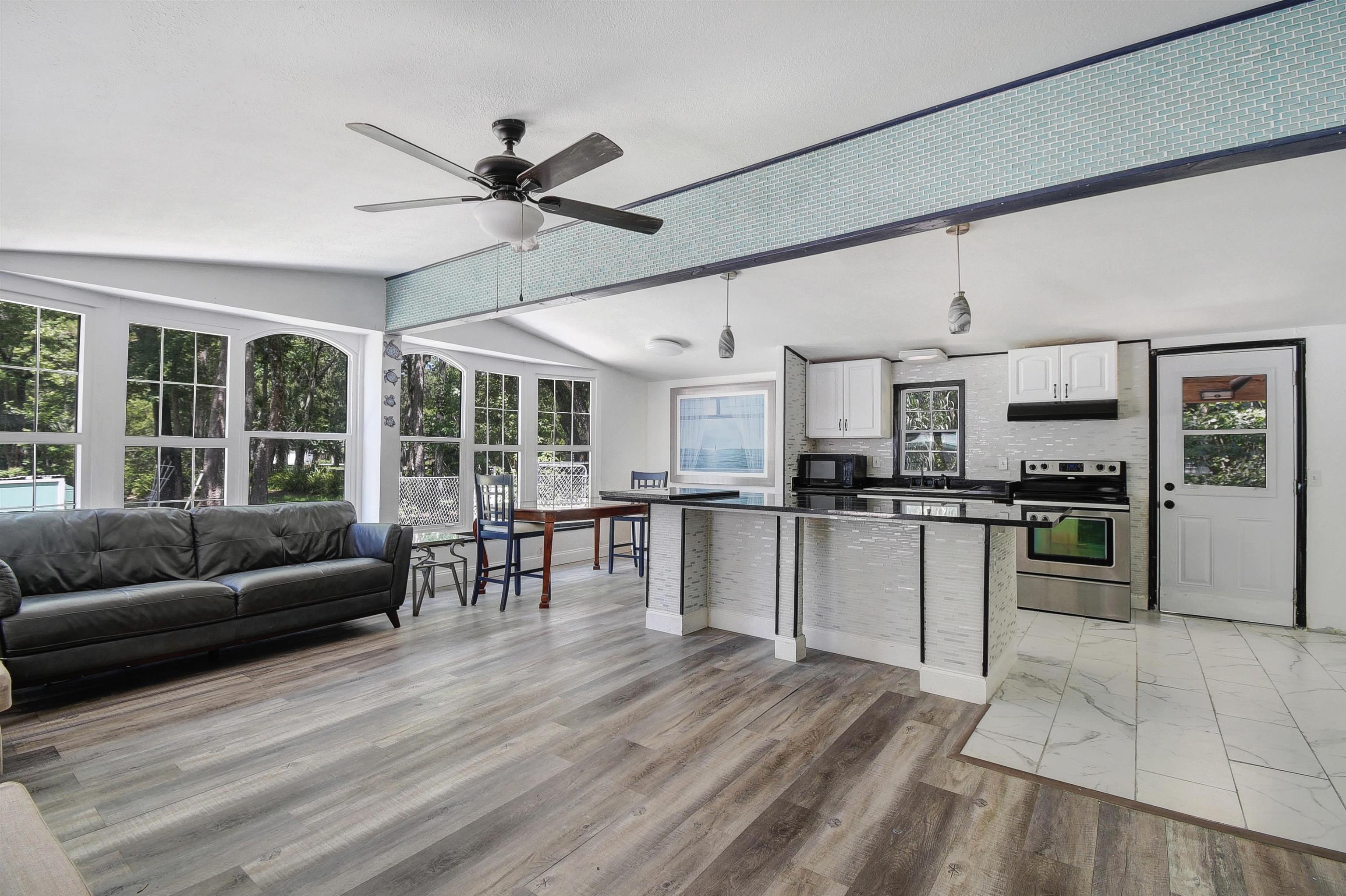 4895 Ave D St. Augustine, FL 32095 - Photo 12 of 25 a living room with stainless steel appliances kitchen island granite countertop furniture and a kitchen view