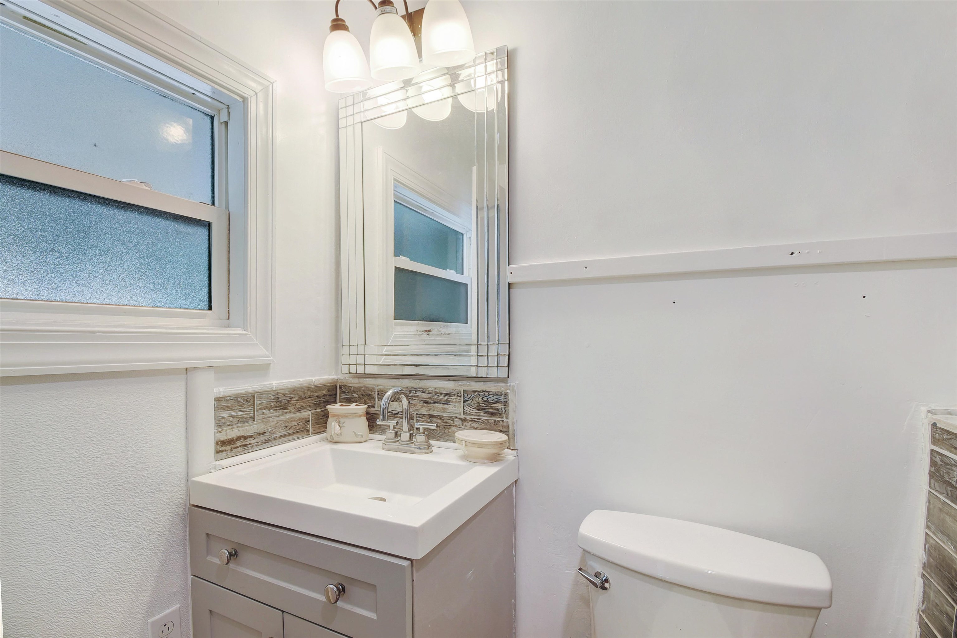 4895 Ave D St. Augustine, FL 32095 - Photo 14 of 25 a bathroom with a sink a toilet and mirror