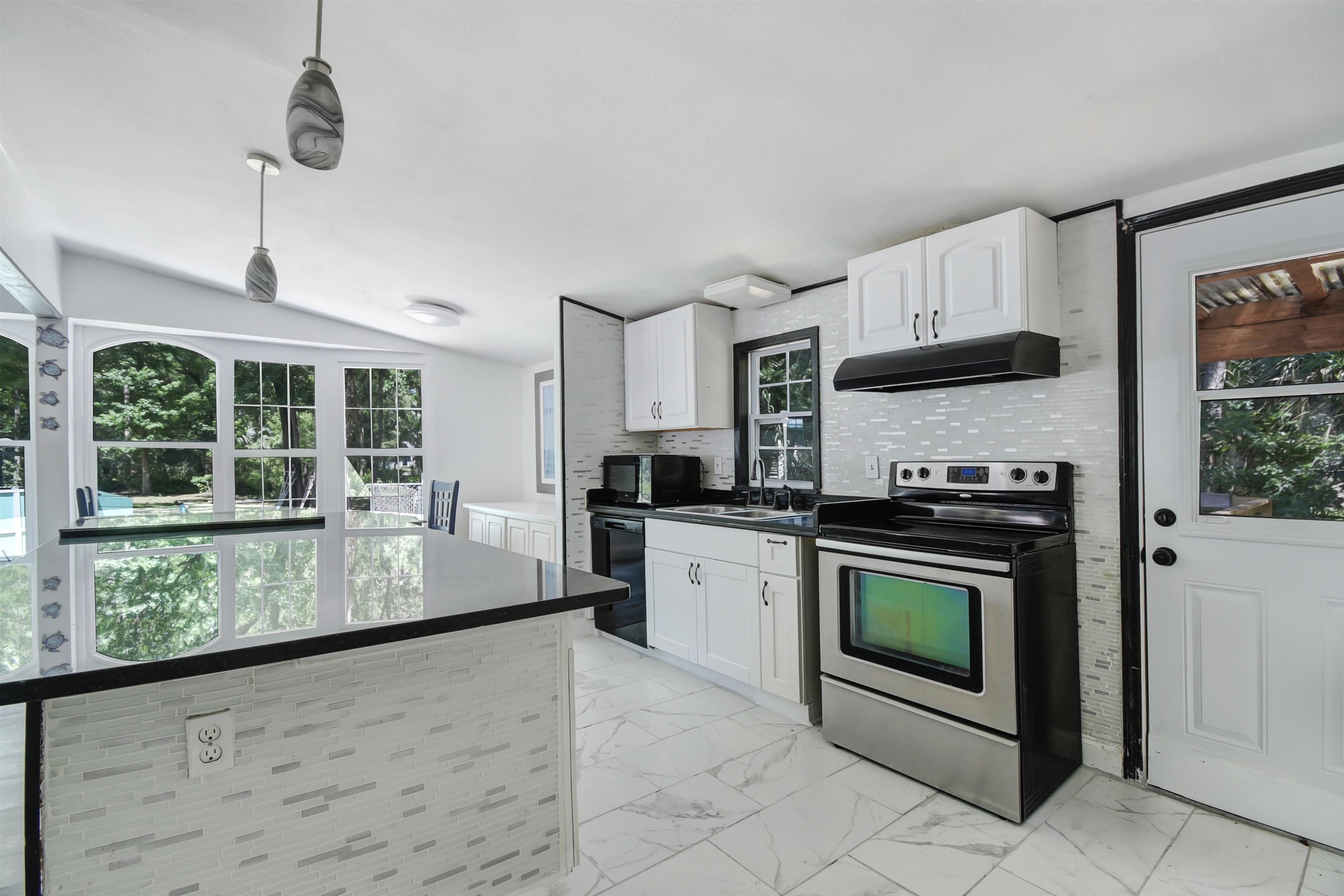 4895 Ave D St. Augustine, FL 32095 - Photo 15 of 25 a kitchen with stainless steel appliances granite countertop a stove a sink and a microwave