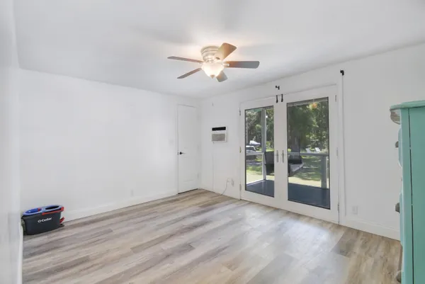 a view of an empty room with window and wooden floor