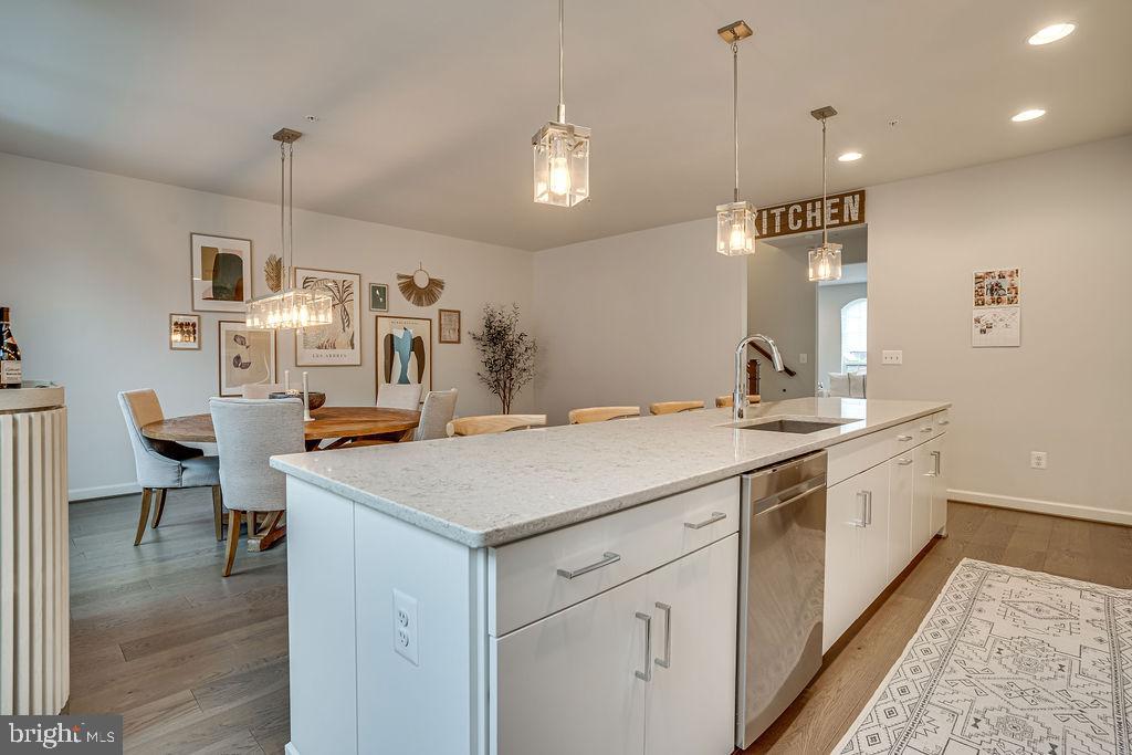 518 Triggerfish Drive Oxon Hill, MD 20745 - Photo 11 of 35 a hall with kitchen island a sink dishwasher a stove and a dining table with wooden floor