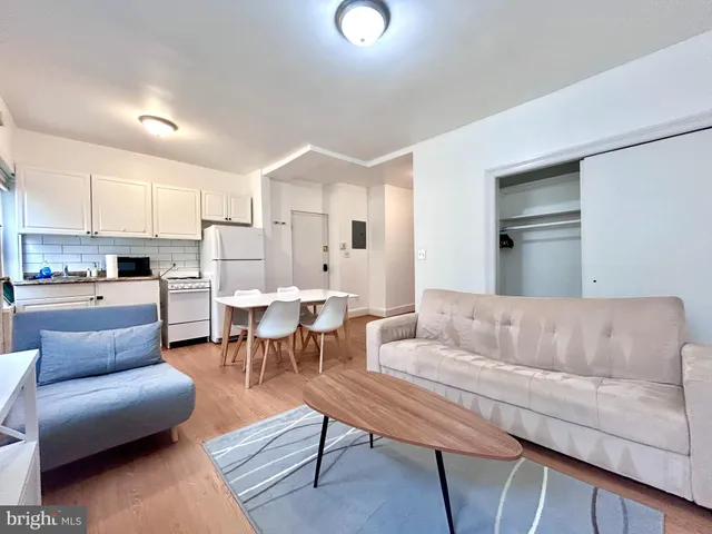 a living room with furniture kitchen and a table