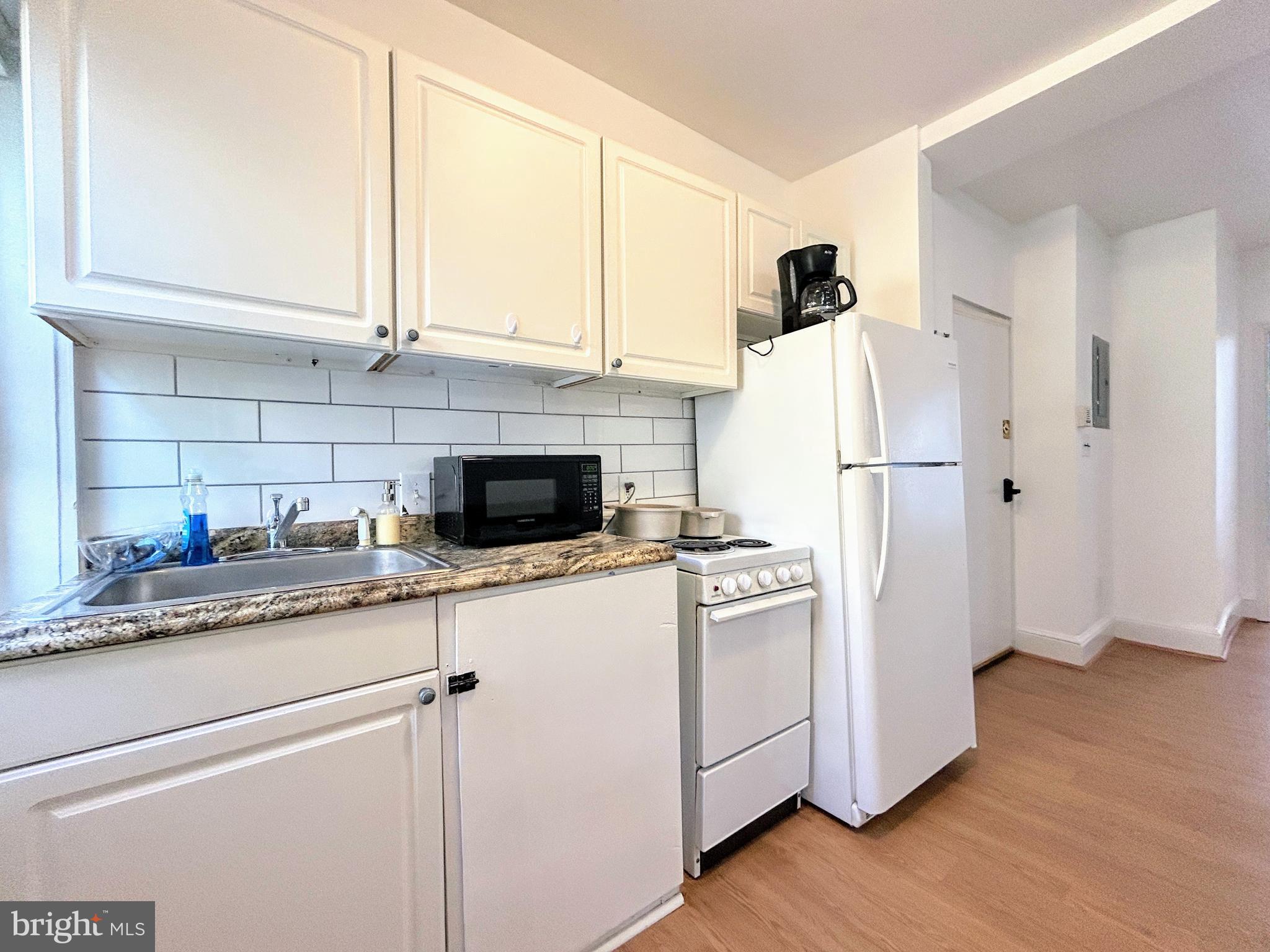 1544 Independence Avenue Southeast, Unit 3 Washington, DC 20003 - Photo 4 of 10 a kitchen with stainless steel appliances granite countertop a refrigerator sink and white cabinets