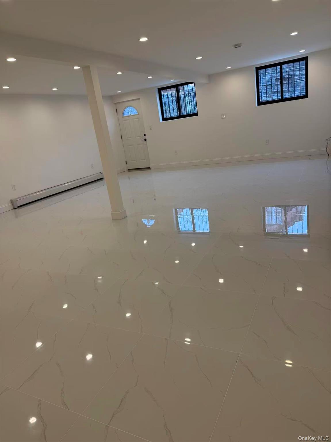 43-44 161 Street Queens, NY 11358 - Photo 12 of 12 Below grade area featuring recessed lighting, baseboard heating, and light marble finish floors