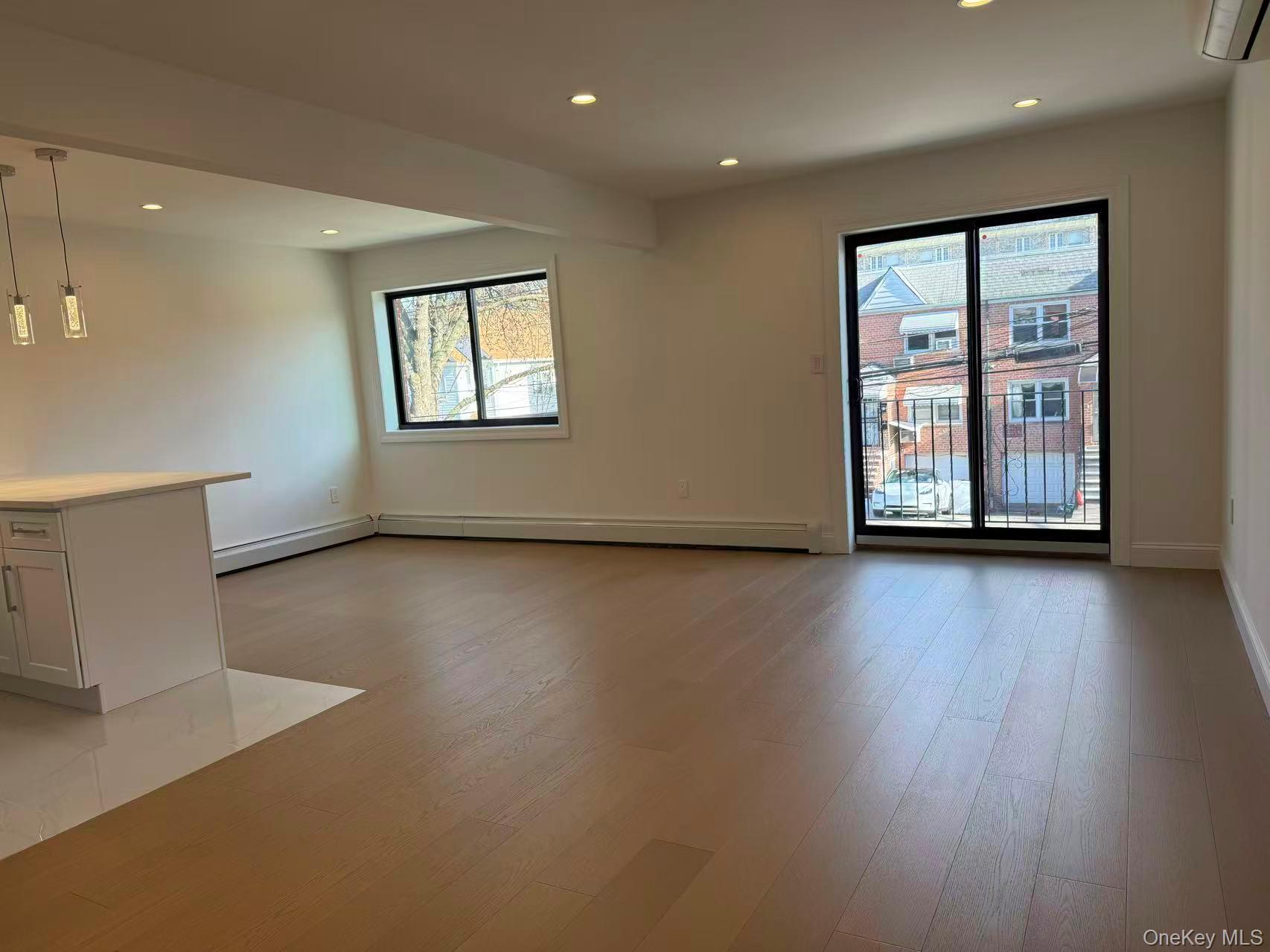43-44 161 Street Queens, NY 11358 - Photo 2 of 12 Unfurnished living room featuring recessed lighting, a wall mounted air conditioner, and light wood-type flooring