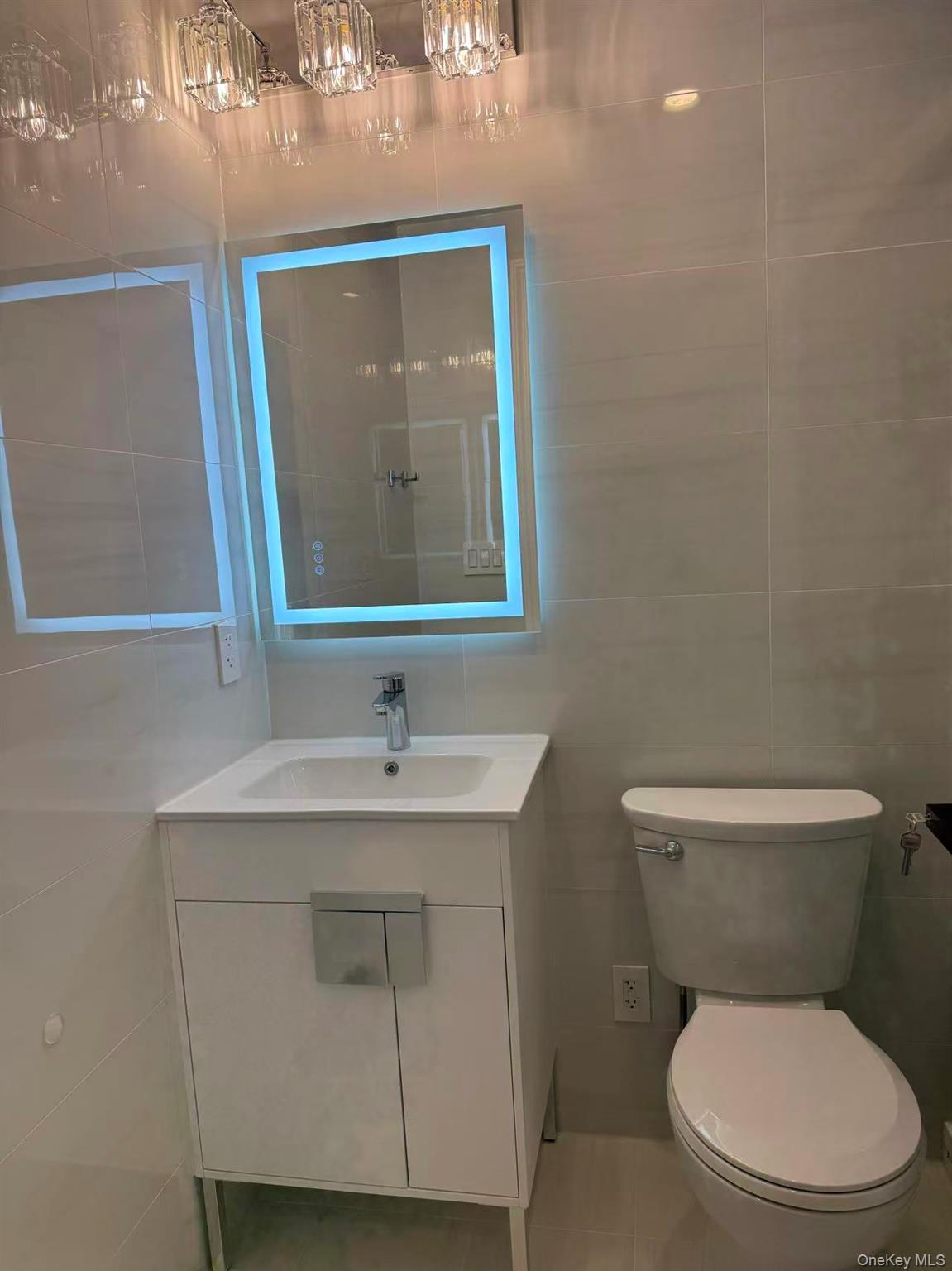 43-44 161 Street Queens, NY 11358 - Photo 8 of 12 Bathroom with tile walls, vanity, and light tile patterned flooring