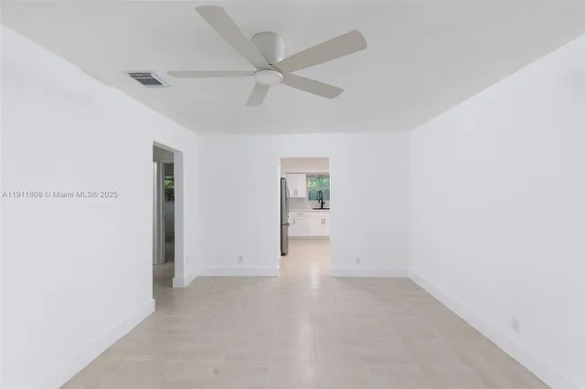 an empty room with a ceiling fan and a window