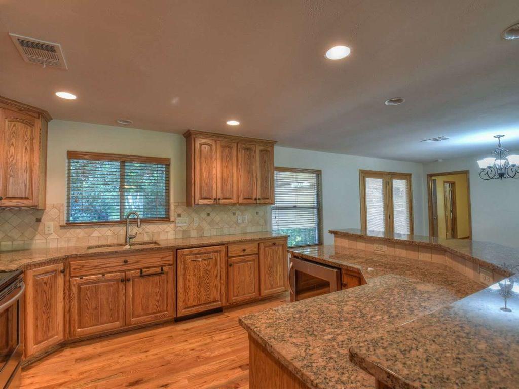 420 7th Street Marble Falls, TX 78654 - Photo 3 of 15 Kitchen featuring brown cabinets, decorative backsplash, light wood-style flooring, recessed lighting, and dishwasher