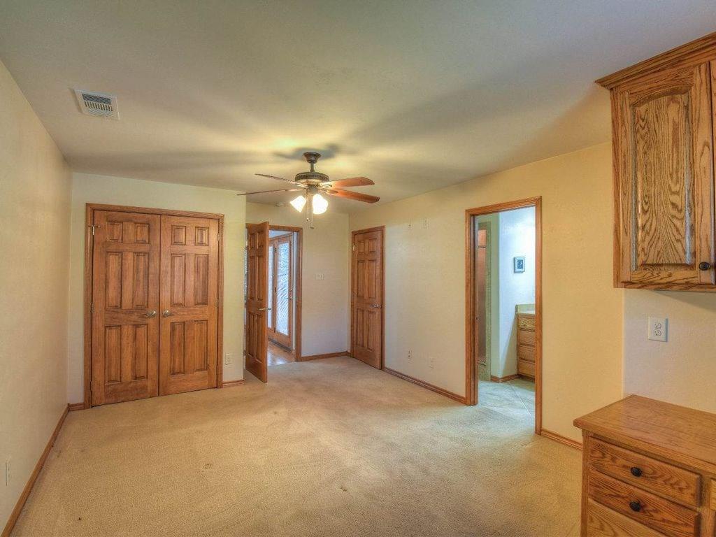 420 7th Street Marble Falls, TX 78654 - Photo 9 of 15 Unfurnished bedroom featuring light carpet, a closet, a ceiling fan, and ensuite bath