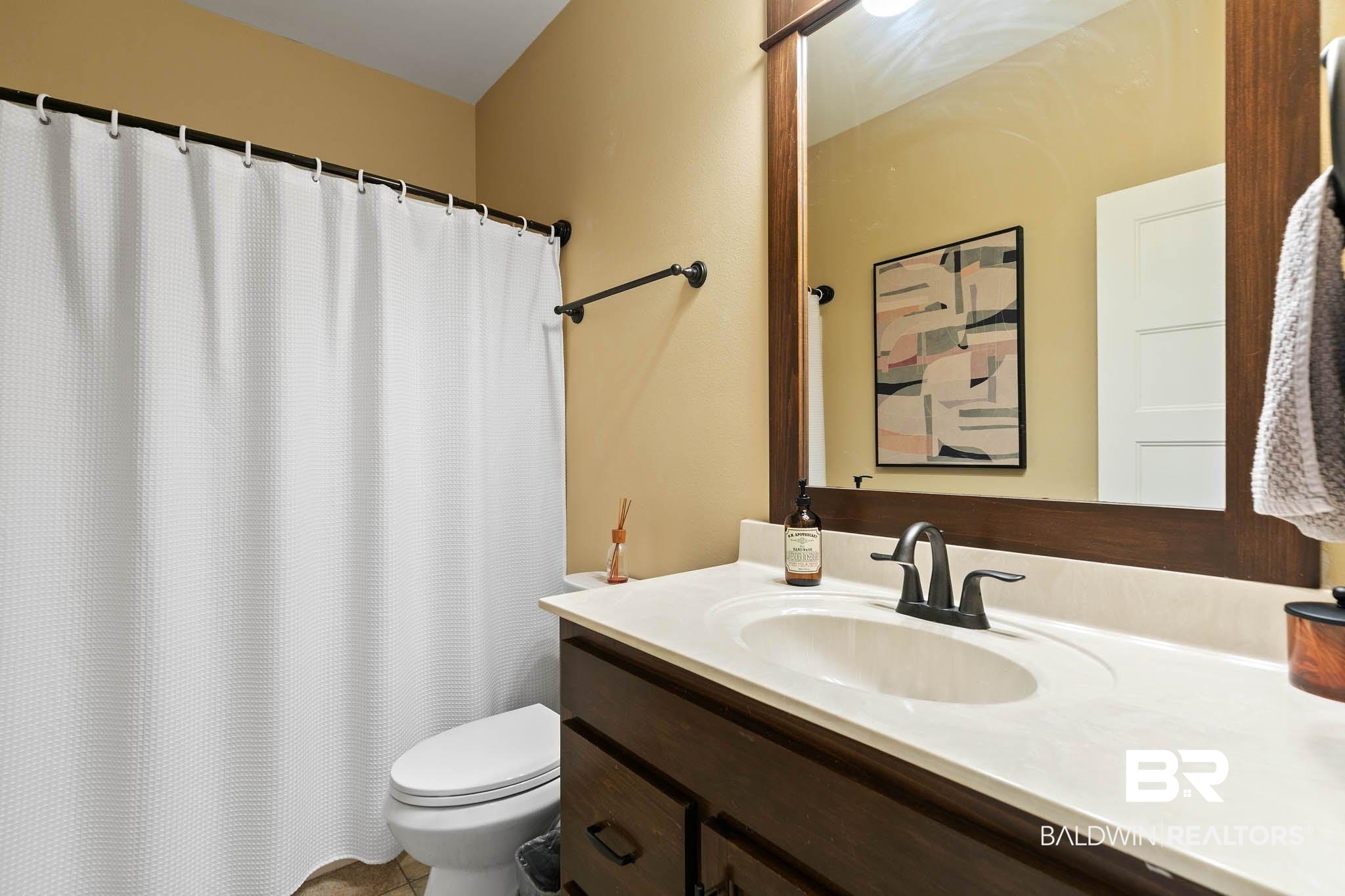 19740 Bunker Loop Fairhope, AL 36532 - Photo 28 of 33 Bathroom with vanity and curtained shower