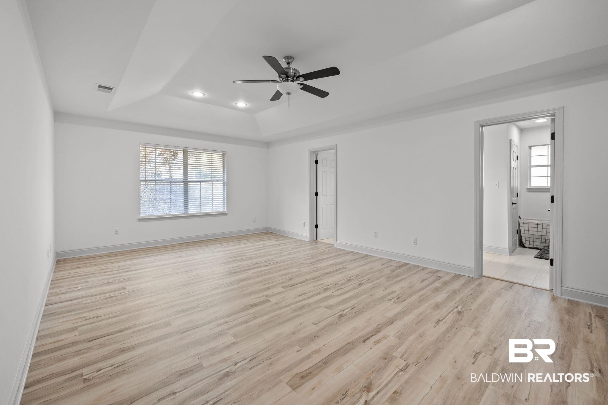 136 Destrehan Road Fairhope, AL 36532 - Photo 31 of 44 Interior space featuring ceiling fan, light hardwood / wood-style flooring, and a tray ceiling