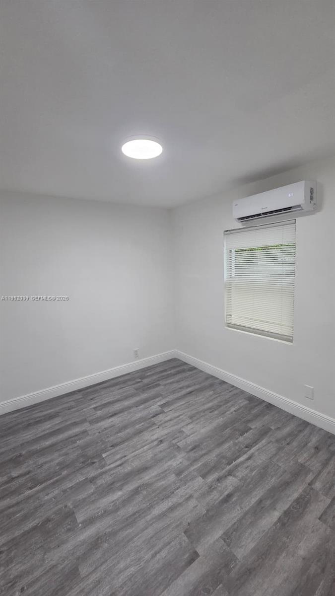 855 Northwest 3rd Terrace, Unit 2 Dania Beach, FL 33004 - Photo 4 of 8 a view of an empty room with wooden floor and a window