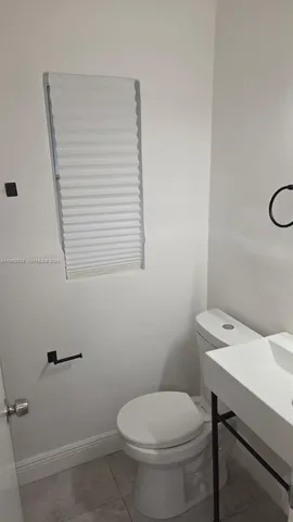 a bathroom with a toilet a sink and a window