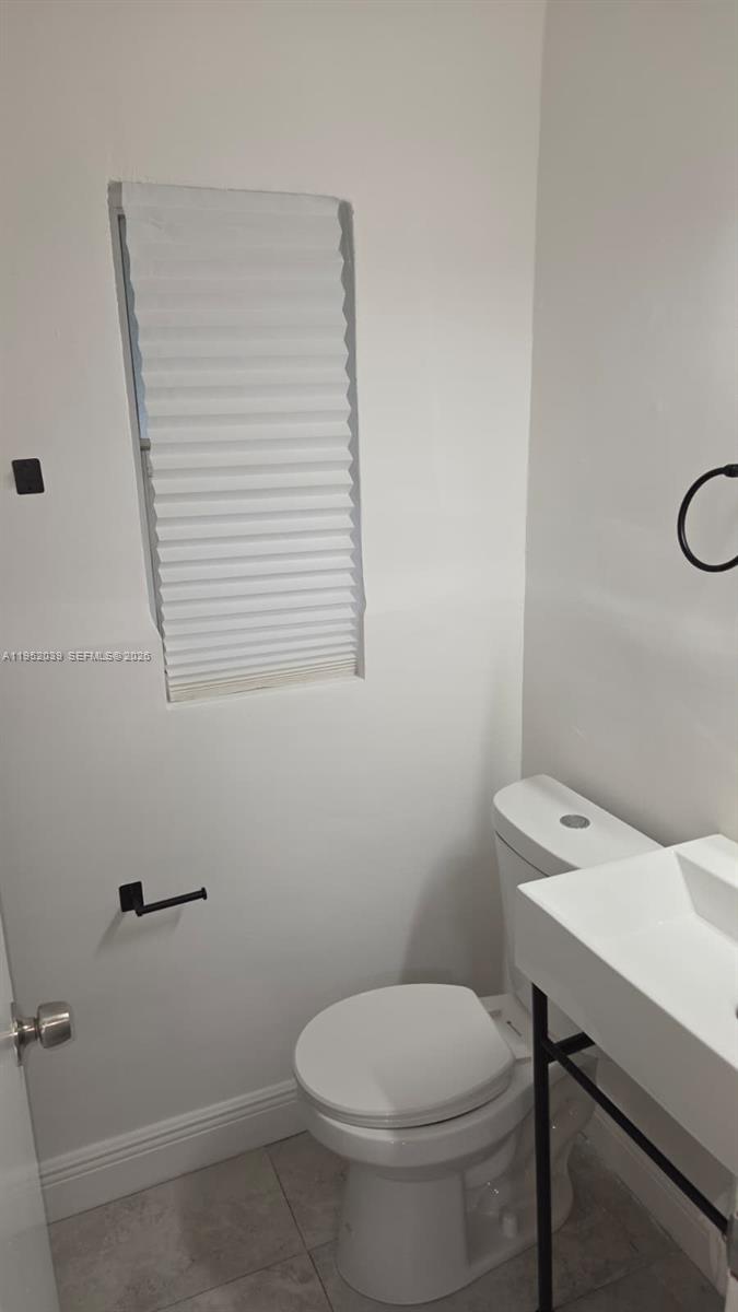 855 Northwest 3rd Terrace, Unit 2 Dania Beach, FL 33004 - Photo 5 of 8 a bathroom with a toilet a sink and a window