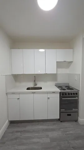 a kitchen with stainless steel appliances a stove a sink and a microwave
