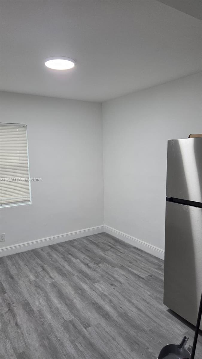 855 Northwest 3rd Terrace, Unit 2 Dania Beach, FL 33004 - Photo 8 of 8 a view of a refrigerator in kitchen and wooden floor