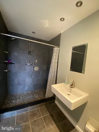 a bathroom with a sink shower and mirror