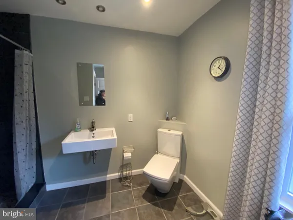 a bathroom with a toilet a sink and mirror