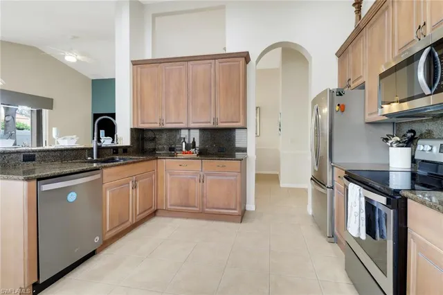 a kitchen with stainless steel appliances granite countertop a stove a sink and a refrigerator