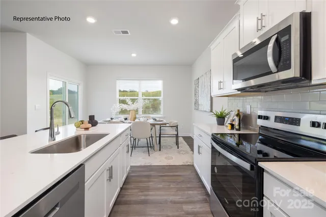 a kitchen with stainless steel appliances a sink dishwasher stove microwave and cabinets