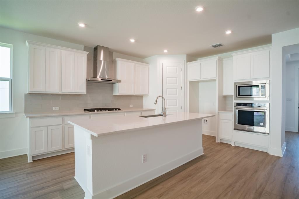 4612 Modena Bay Bend Leander, TX 78641 - Photo 11 of 34 Kitchen with stainless steel appliances, white cabinets, an island with sink, and recessed lighting