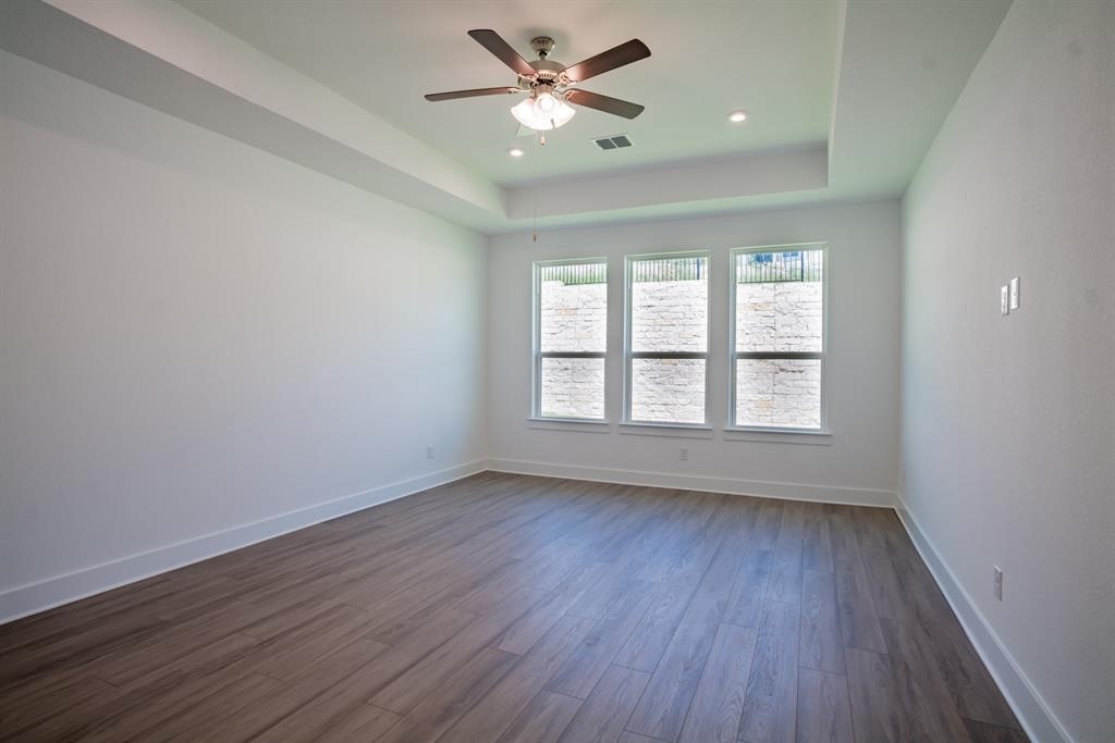 4612 Modena Bay Bend Leander, TX 78641 - Photo 26 of 34 Empty room featuring dark wood-style floors, a tray ceiling, recessed lighting, and ceiling fan