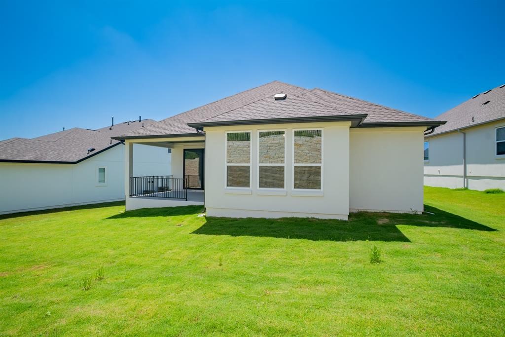 4612 Modena Bay Bend Leander, TX 78641 - Photo 31 of 34 Back of house with a yard, a patio, a shingled roof, and stucco siding