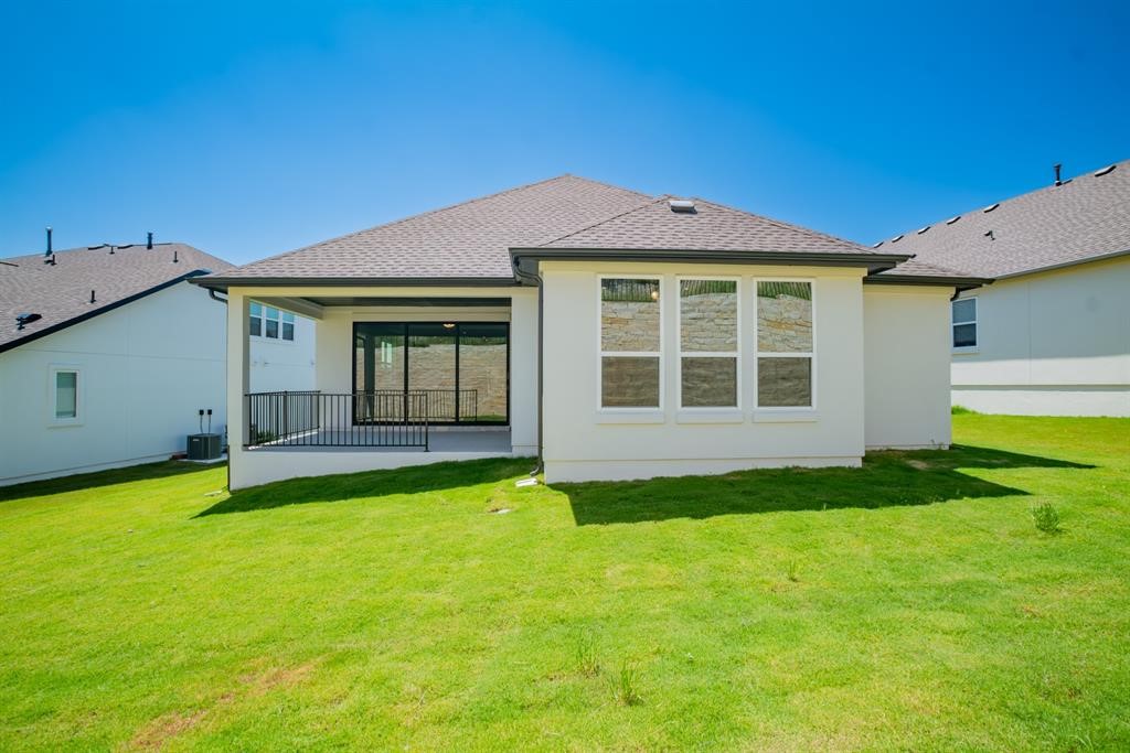 4612 Modena Bay Bend Leander, TX 78641 - Photo 32 of 34 Back of house with a patio area, a yard, and stucco siding