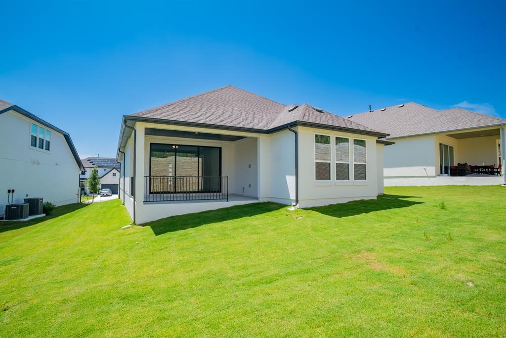 4612 Modena Bay Bend Leander, TX 78641 - Photo 33 of 34 Rear view of property with a lawn, a patio area, a shingled roof, and stucco siding