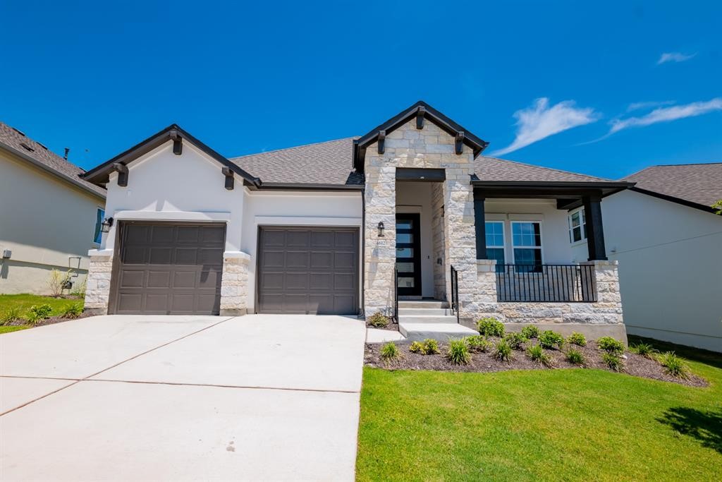 4612 Modena Bay Bend Leander, TX 78641 - Photo 34 of 34 View of front facade with stone siding, stucco siding, driveway, a front yard, and covered porch