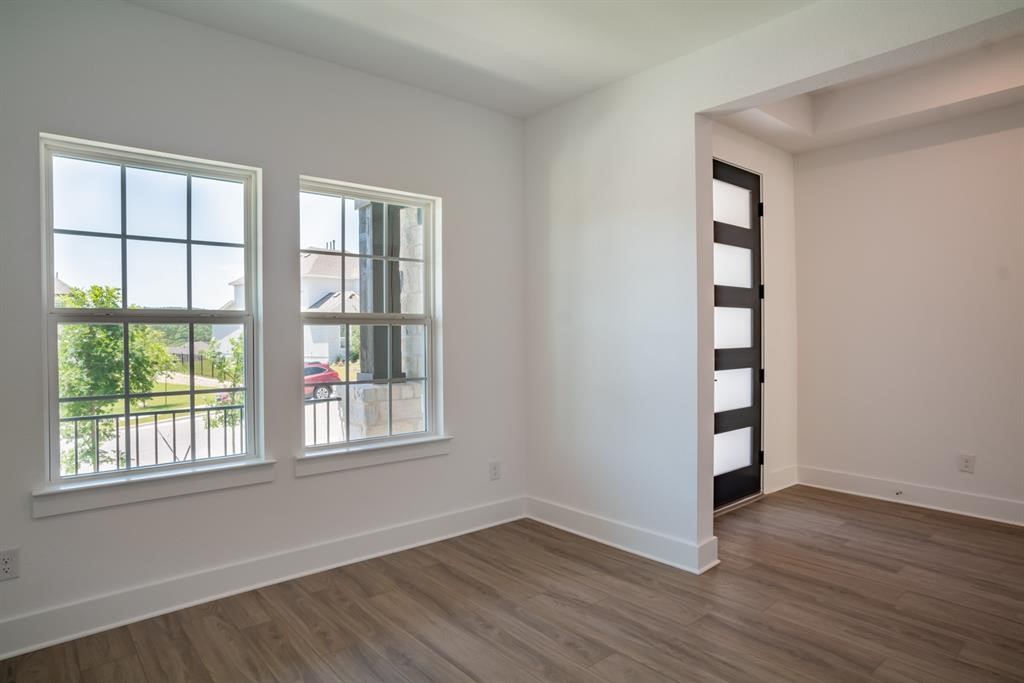 4612 Modena Bay Bend Leander, TX 78641 - Photo 6 of 34 Empty room featuring baseboards and dark wood-style flooring