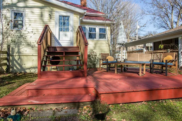 a backyard of a house with barbeque oven table and chairs