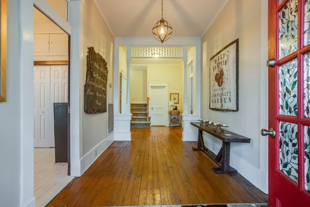 a view of a hallway with wooden floor and furniture