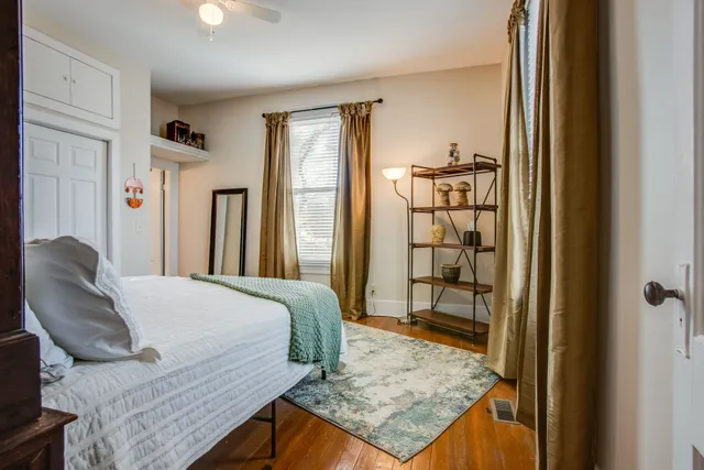 a bedroom with a bed and wooden floor