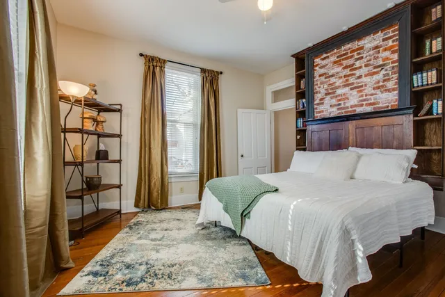 a bedroom with a large bed and a book shelf