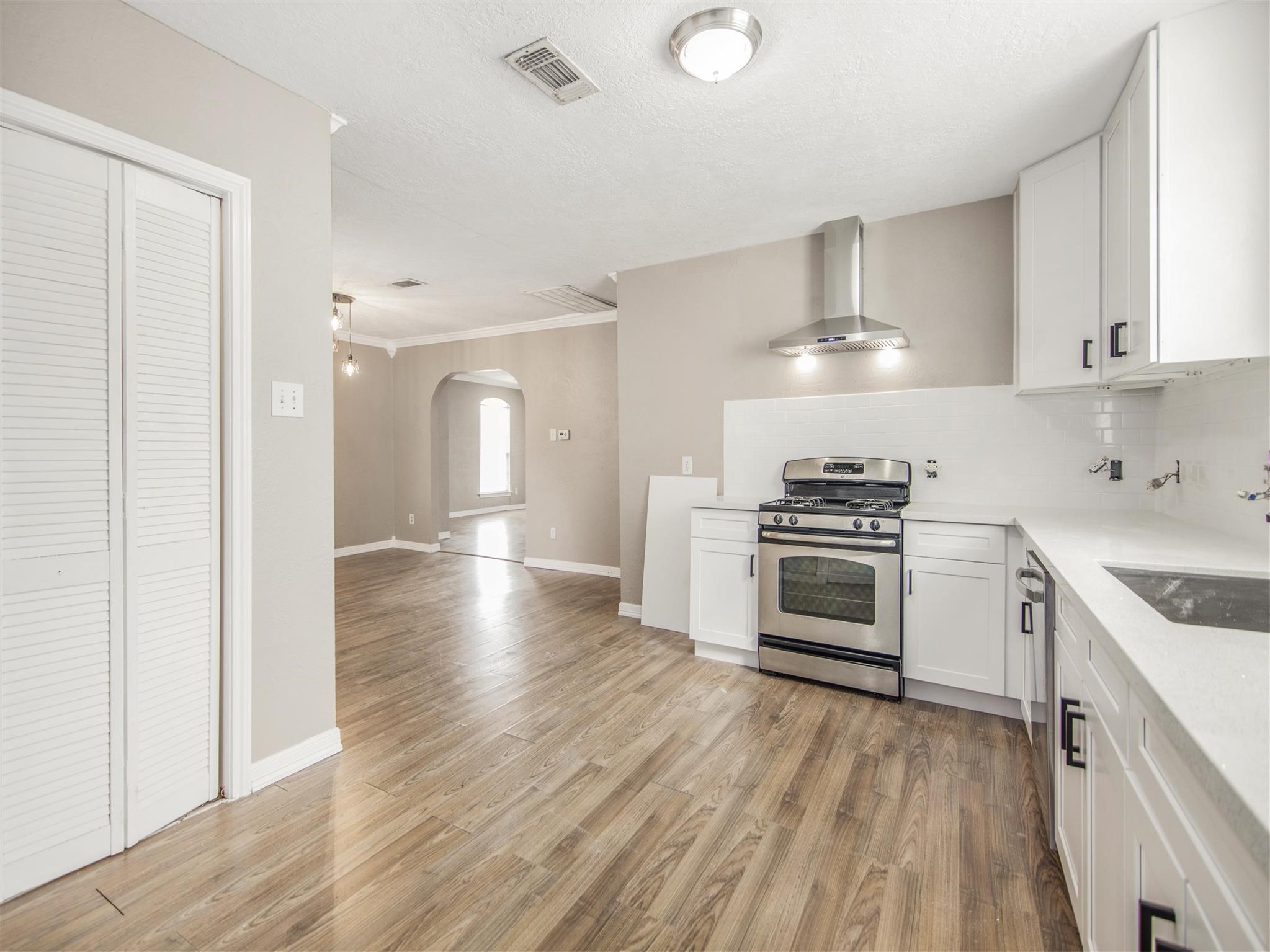 5108 Clay Street Houston, TX 77023 - Photo 11 of 21 a kitchen with stainless steel appliances a white stove top oven cabinets and a wooden floor