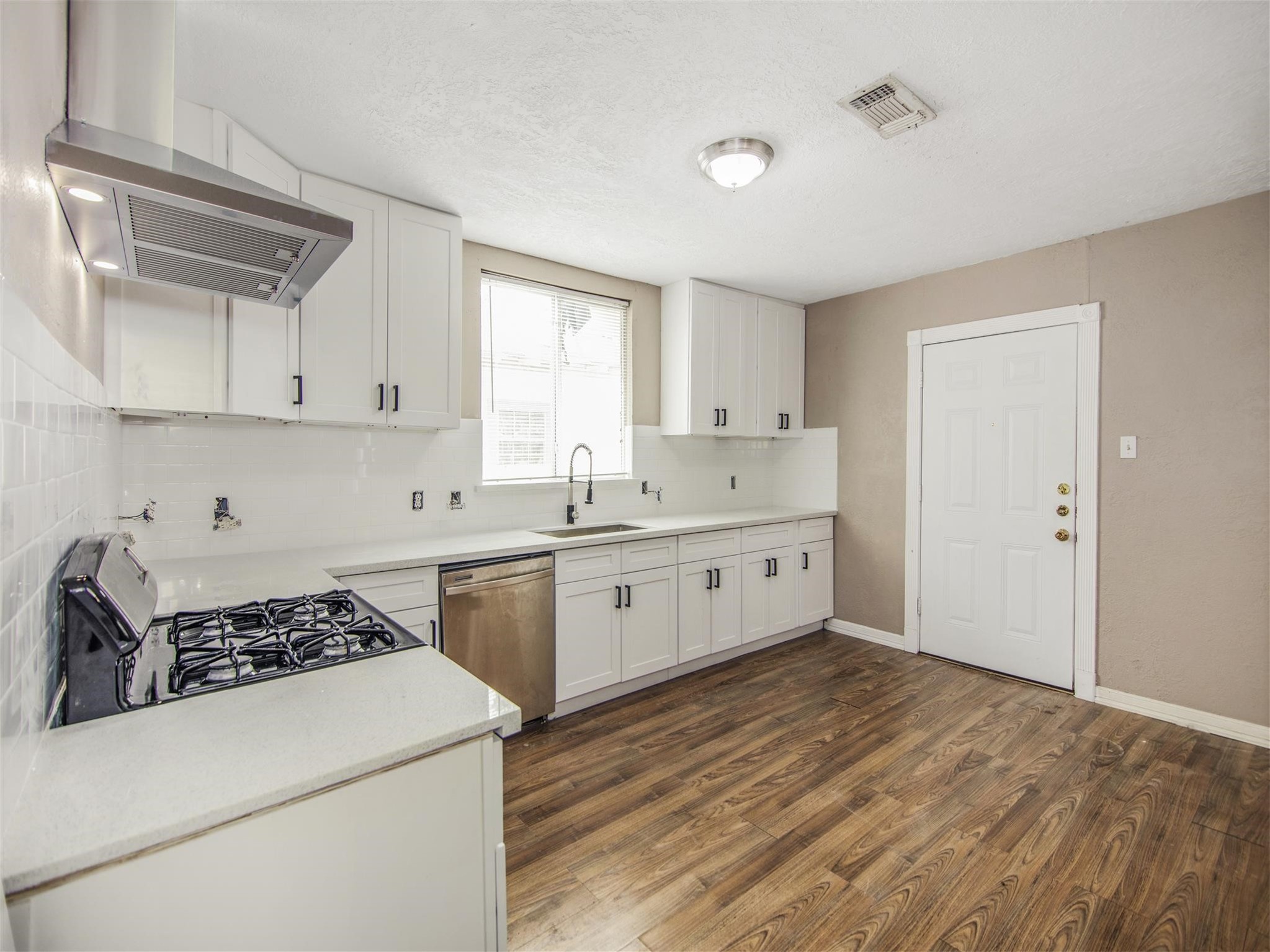 5108 Clay Street Houston, TX 77023 - Photo 12 of 21 a kitchen with a stove a sink and a refrigerator