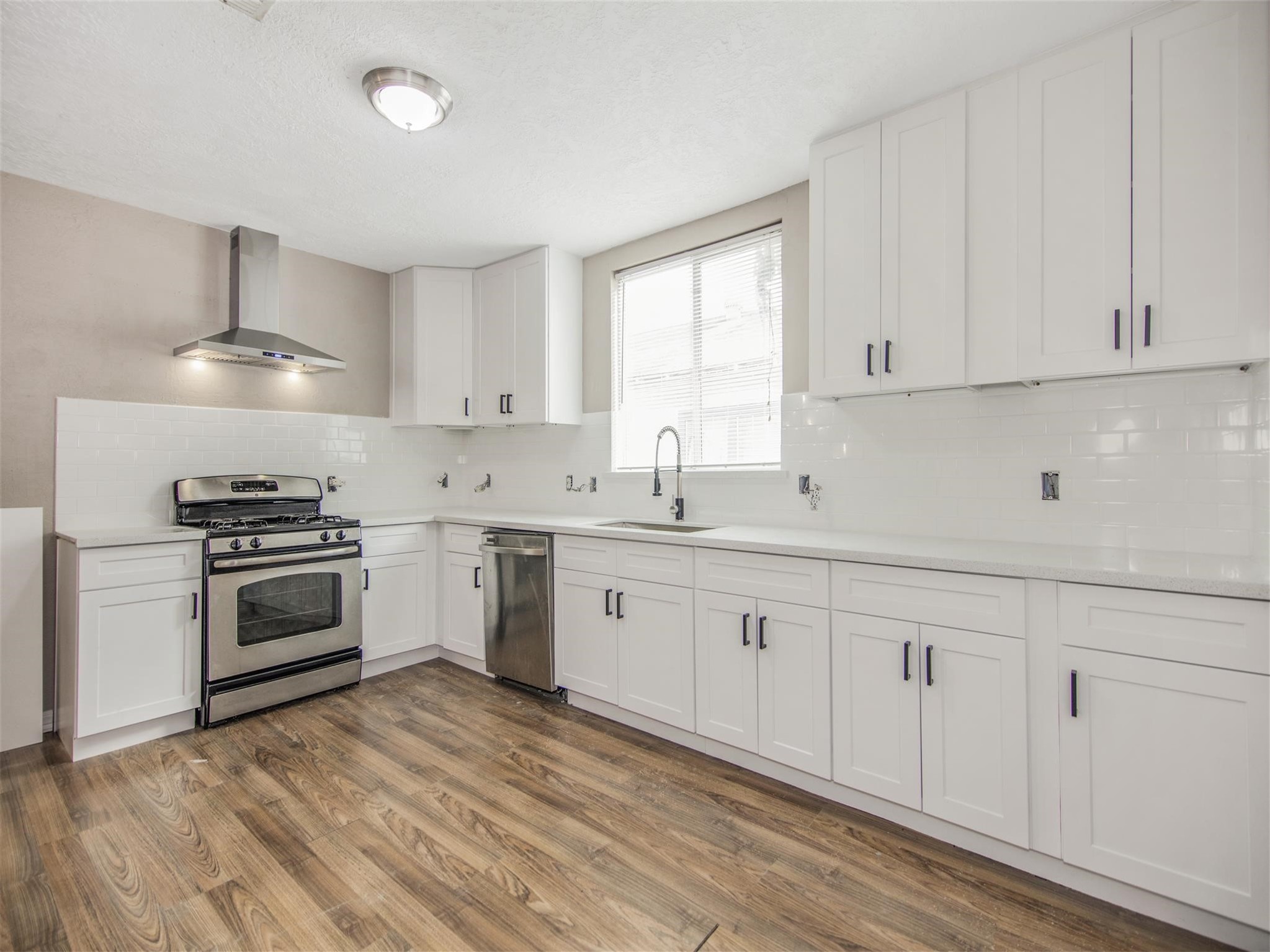 5108 Clay Street Houston, TX 77023 - Photo 13 of 21 a kitchen with granite countertop white cabinets and white appliances